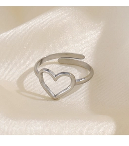 Detail of silver heart-shaped hollow ring with adjustable open band on satin silk background