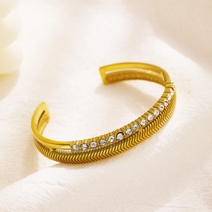 Detail view of gold stainless steel bracelet with zircon inlay and fishbone engraving