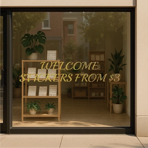 Close-up of sparkling gold glitter welcome sticker on shop window glass surface