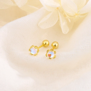 Elegant s925 gold moonstone stud earrings on soft white fabric background