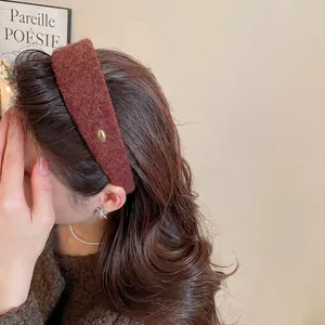 Serre-tête large en velours marron élégant avec logo doré porté par un modèle style automne