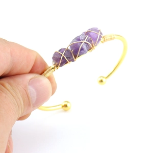 Handmade gold wire-wrapped bangle featuring three natural purple amethyst raw crystals