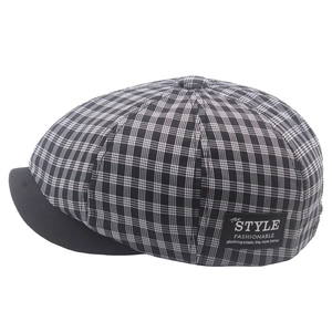 Vintage black and white plaid newsboy hat with a curved brim and decorative side label