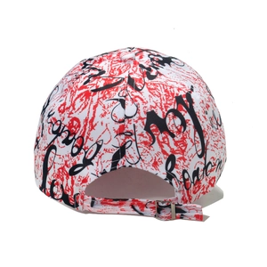 Detail of street-style baseball cap featuring red graffiti and adjustable metal buckle