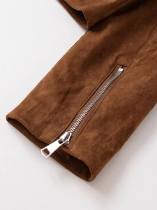 Detail of a brown suede jacket sleeve featuring a polished silver metal zipper closure