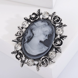 Macro view of vintage silver flower brooch with white cameo relief and crystal inlay