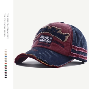 Detail of vintage washed baseball cap featuring distressed holes and 1969 embroidery