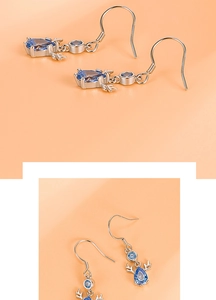 Macro detail of S999 sterling silver reindeer earrings with blue pear-cut gemstones