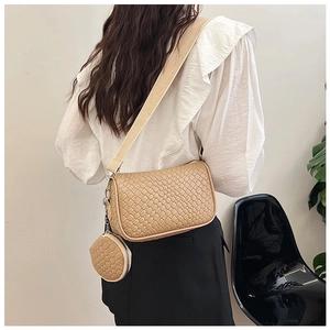 Detail of beige woven texture shoulder bag with round coin purse and wide strap