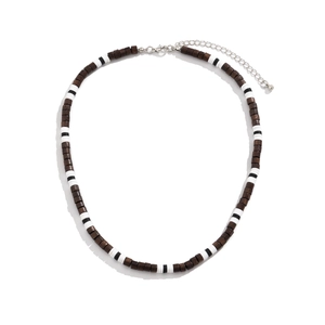 Bohemian men's necklace featuring dark wood beads and black white clay discs on white background