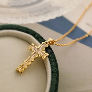 Elegant gold-plated cross pendant necklace with sparkling cubic zirconia on green velvet box