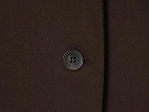 Detail of dark brown suit fabric with a premium black four-hole resin button