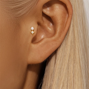 Macro shot of gold S925 silver tragus stud featuring round and star zircon stones