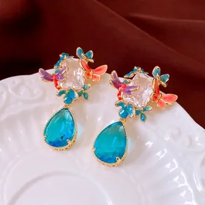 Retro butterfly dangle earrings with gold plating, blue gemstones and enamel flowers