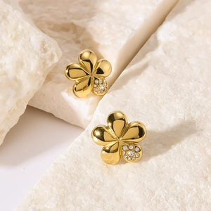 Golden five-petal flower stud earrings with sparkling crystals on textured stone base