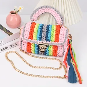 Detail of colorful hand-woven crochet bag with metallic gold lock and fabric fringe charm
