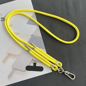 Detail of yellow nylon crossbody phone lanyard with adjustable silver metal buckle and patch