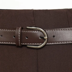 Jupe plissée marron longueur genou avec une ceinture fine en cuir et surpiqûres blanches