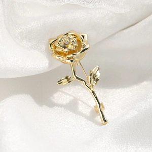 Elegant gold-plated rose brooch pin for suits on white silk background