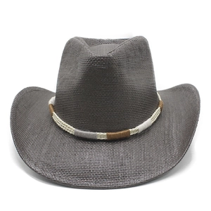 Detail of woven straw cowboy hat featuring a colorful ethnic patterned hatband and wide brim