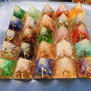 Macro view of crystal resin pyramids with natural gemstones and golden rune symbols