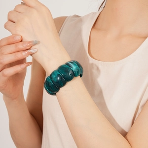 Macro shot of dark green acrylic wide cuff bracelet with marble texture on model wrist