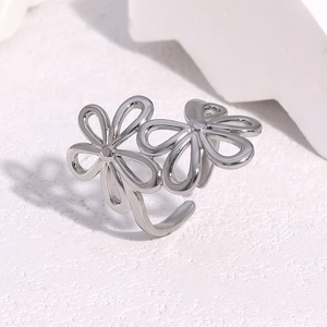 Polished stainless steel open ring with dual hollow flower design on stone background