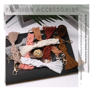 Macro detail of handmade bohemian woven cotton keychains with golden metal clasps and tassels