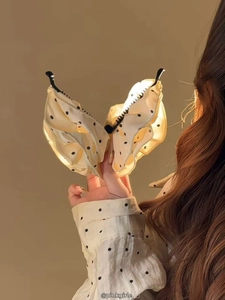 Détail d'une grande pince à cheveux en tissu à pois pour des coiffures élégantes à la française