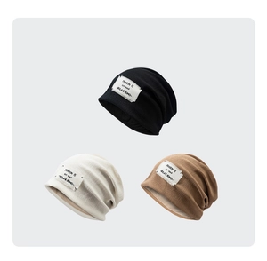 Detailed close-up of beanies in black, beige, and tan featuring soft silk lining texture