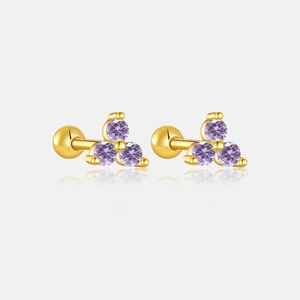 Macro detail of gold S925 silver stud earrings featuring three purple cubic zirconia stones