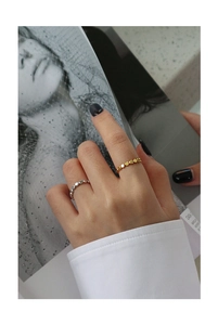Detail view of gold and silver beaded S925 sterling silver rings on a model hand