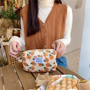 Détail de la trousse de maquillage en velours floral avec zip et poignée latérale