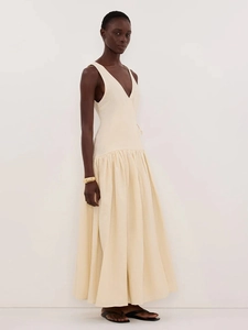 Détail d'une robe longue en coton à col en V avec lien à la taille et jupe plissée