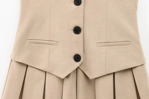 Dettagli del set gilet beige e gonna a pieghe con bottoni neri e trama in tessuto