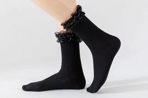 Détail de chaussettes mi-mollet noires avec tricot vertical et volants en organza