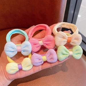 Detail of six bow-knot hair ties in pastel macaron colors with soft velvet texture