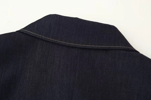 Détail des surpiqûres jaunes contrastées sur col en denim bleu foncé et texture du tissu