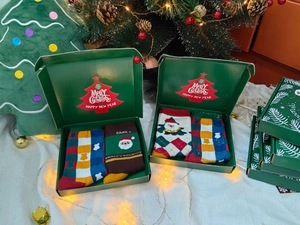 Close-up of festive cotton Christmas socks in a gift box with holiday decorations