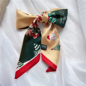 Macro detail of Christmas silk scarf with tree and snowman patterns on white fabric
