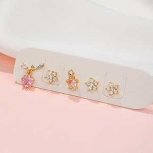 Detailed view of 5-piece earring set with pink flowers, stars and zircon stones