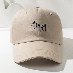 Détail d'une casquette beige avec broderie minimaliste de promesse et coutures précises