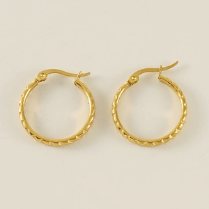 Close-up of golden textured hoop earrings with secure click-top clasp on beige background
