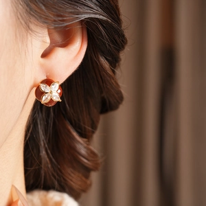 Close-up of model wearing a vintage red flower stud earring with sparkling crystals
