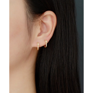 Elegant gold S925 sterling silver huggie earrings with sparkling inlaid zircons on model