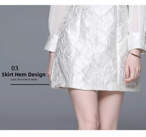 Detailed view of white jacquard floral dress hem and lightweight fabric texture