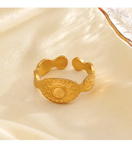 Detailed macro view of vintage matte gold ring featuring embossed dots on a satin background