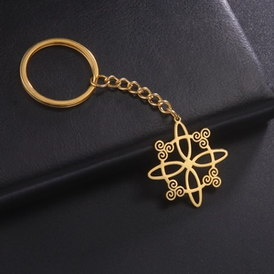 Detail of a golden stainless steel Celtic knot pendant on a textured black leather background