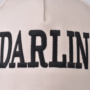 Close-up of beige cotton baseball cap with high-quality black DARLIN embroidery