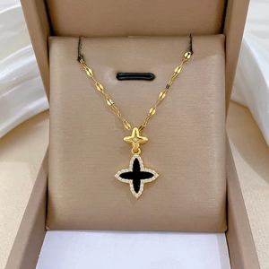 Macro detail of a gold clover pendant with black onyx finish and pavé diamonds